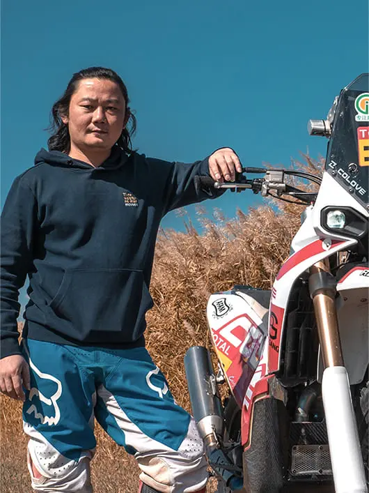 ZXMOTO founder Zhang Xue beside a rally motorcycle